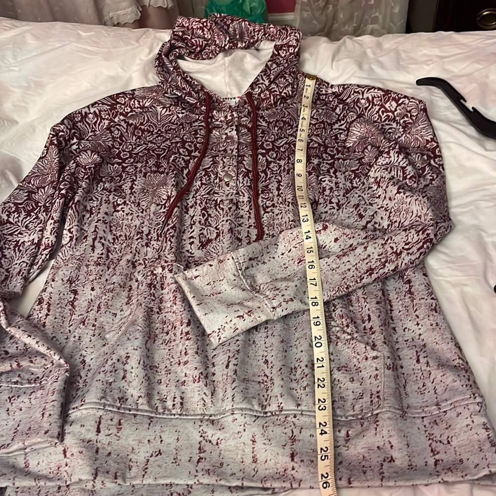 Hooded unique pattern top with snap placket.